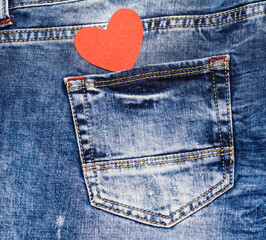 Red heart in jeans pocket. Love symbol. Valentine's card.