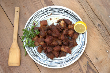 grilled pork with french fries and salad on a wooden table