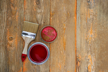 Paint can and brush on the old wooden background.
