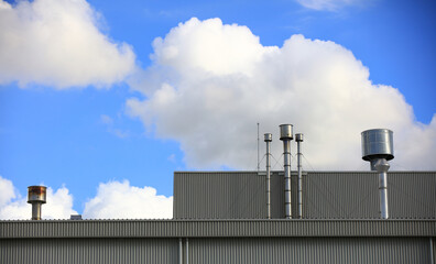 Obraz premium smokestack of factory against blue sky