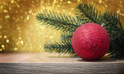 Red Christmas ball on abstract gold glitter bokeh background