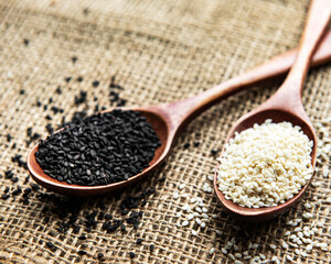 Black and white sesame seeds in a spoons