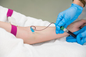 Laboratory worker doctor takes a blood sample for analysis, hand closeup. Blood sampling in the laboratory. Taking a blood in cosmetology clinic before PRP therapy procedure.