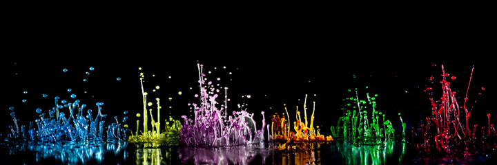 tanzende farbige Wassertropfen auf schwarzem Hintergrund
