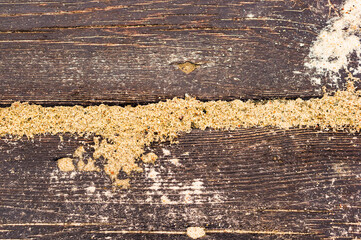 High angle shot of sand filling the cracks of a wooden sandbox