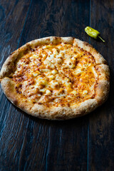 Pizza Quattro Formaggi Four Cheese Pizza on Wooden Surface.