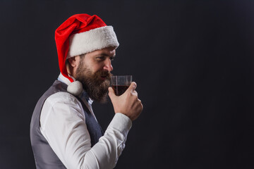 Whiskey tasting. Sommelier. Santa drinks whiskey. whiskey degustation. New year celebration. Bearded man with glass of whisky. Santa with whisky. Eau-de-vie. Usquebaugh.