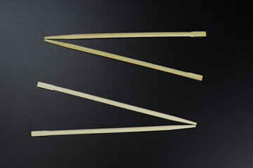 Wooden chopsticks, sushi sticks on a black background