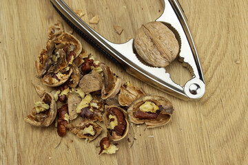 Peeled Walnut and metal Nutcracker on a wooden Board
