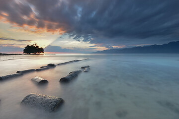 The sunrise illuminating the trees, and the sky was beautiful with the clouds