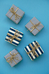 Fototapeta premium Holiday gifts decorated with striped paper on a blue background