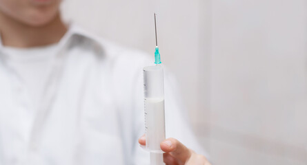 a drop of liquid at the tip of the syringe needle
