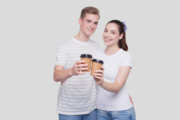 Couple Holding Coffee Cups Watching to Camera Isolated. Couple Standing and Holding Coffee to go Cup. Man and Woman Hugging, Lovers, Friends, Couple Concept.