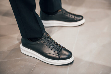 Fototapeta na wymiar Close up view of man's legs in modern new luxury black shoes