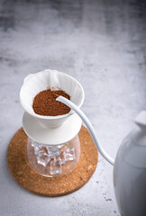 Drip brewing, filtered coffee or pour-over is a way of making coffee. Barista preparing drip on iced on coffee ground coffee beans contained in a filter paper.