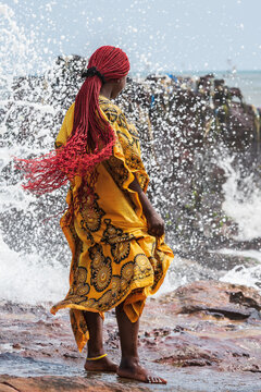 African woman at the cliffs as the waves crash on the shore, Accra Ghana West Africa