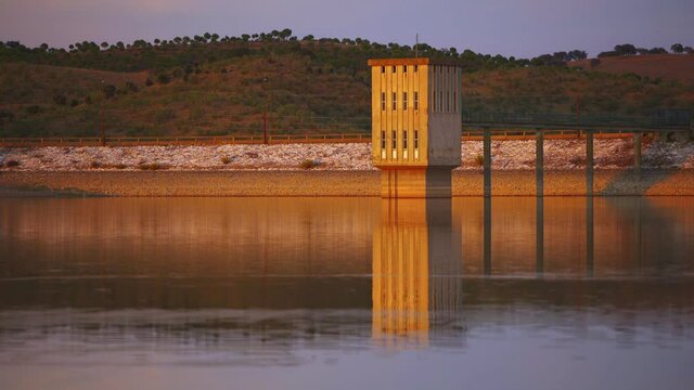 Lucefecit Dam in Terena with reflection on the lake reservoir at sunset, in Portugal