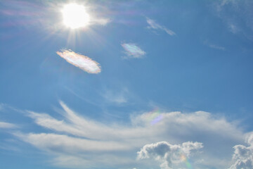 Fototapeta na wymiar Sun and clouds on the blue sky