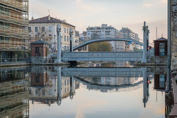 Paris, France - 11 07 2020: Reflections on the Ourcq canal of the lift bridge at sunrise