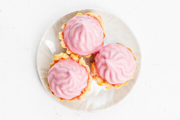Mini cakes baskets with raspberry cream on white plate
