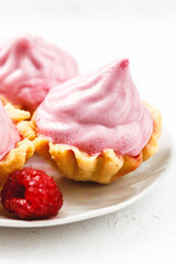 Mini cakes baskets with raspberry cream on white plate