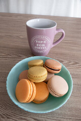 Sweet French Macarons in different colors with a Pink Coffee Mug