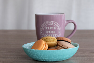 Sweet French Macarons in different colors with a Pink Coffee Mug
