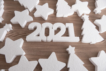 White 2021 new year number, stars and Christmas trees on wooden background