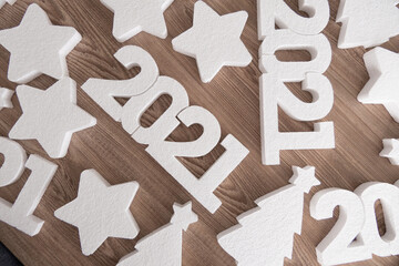 White 2021 new year number, stars and Christmas trees on wooden background