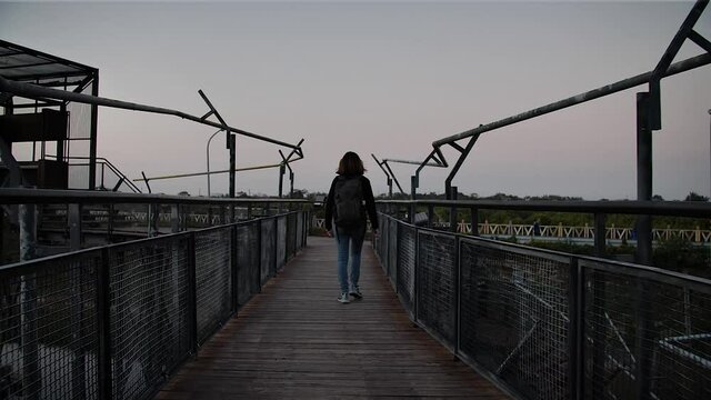 Girl walking in the city high line at evening in Kaohsiung, Taiwan. High angle, traveling movement, slow motion, HD.