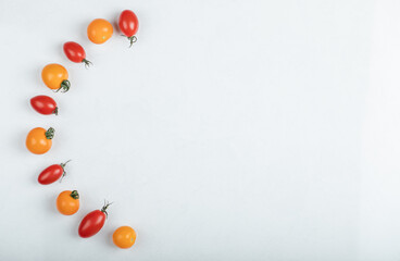 Wide angle Gleaming red and yellow tomatoes on white background