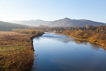 Obraz premium Autumn morning on Stryi river, mountains on the horison. Ukraine, Carpathians.