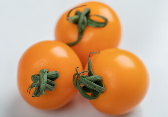 Yellow tomatoes on light white background, flat lay