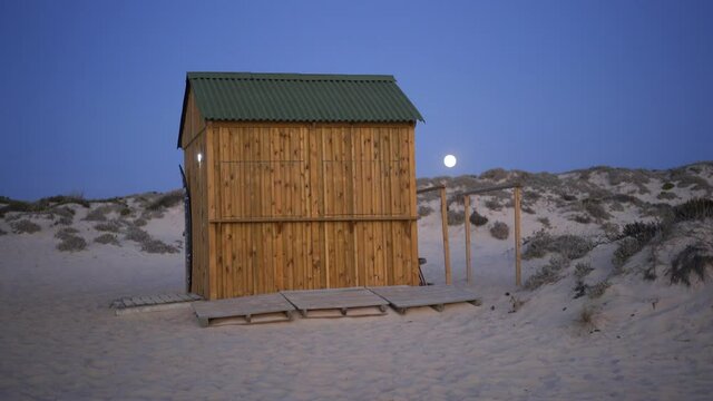 Wooden houses for fisherman on an empty beach at night in Comporta, Portugal