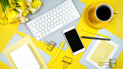 2021 colors of the year, yellow and gray, desktop workspace with keyboard, smart phone and desk accessories. Top view blog hero header creative composition flat lay.