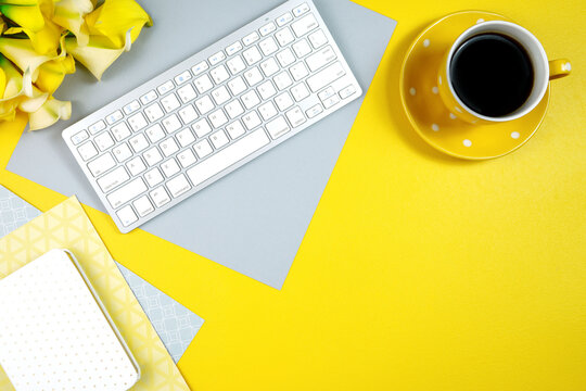 2021 colors of the year, yellow and gray, desktop workspace with keyboard and desk accessories. Top view blog hero header creative composition flat lay. Negative copy space.