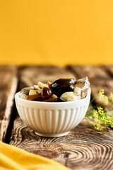 Marinated mushrooms in glass jar, herbs and spices on wooden table. Canned vegetatian dish. Natural light. Selective focus.