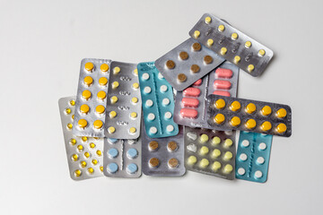 Colorful tablets vitamins and antibiotics in blisters lie beautifully on a white background