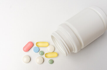 Colorful pills vitamins and antibiotics lie beautifully on a white background