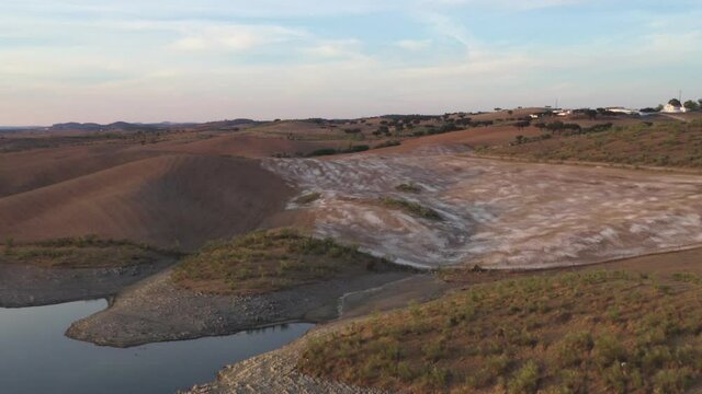 Drone aerial panorama of a desert like hill landscape with marble stones dust at sunset in Terena, Portugal