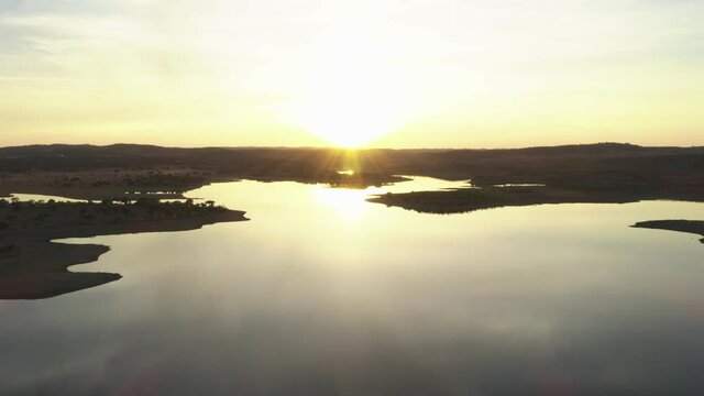 Drone aerial panorama of a dam lake reservoir landscape with olive and cork trees in Alentejo Terena, Portugal