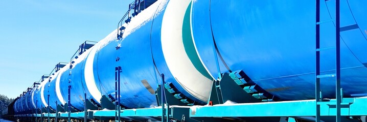 Blue cargo train on the move in winter, wagons close-up. Freight transportation, fuel and power generation, global communications, logistics, delivery, industry, technology, railway. Panoramic image