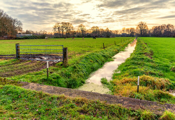 December sunset over a polder landscape with a ditch in Lunteren NL