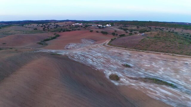 Drone aerial panorama of a desert like hill landscape with marble stones dust at sunset in Terena, Portugal