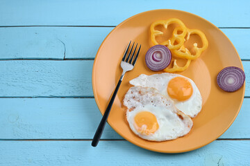 Fried egg on a orange plate. Top view. Breakfast