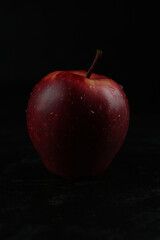Red apple isolated on the black wooden background