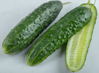 Close-up of fresh cucumbers and slices isolated on white background.