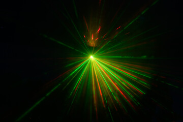 Fototapeta na wymiar green and red laser beams on a black background