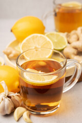 Hot herbal tea with ginger, garlic, lemon and honey vitamins C over grey background. Concept alternative medicine, natural homemade remedy for cold and flu. Support the immune system. Well-Being and