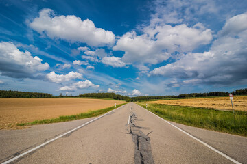 Green field with agriculture meadow and blue sky. Panoramic view to grass on the hill on sunny spring day